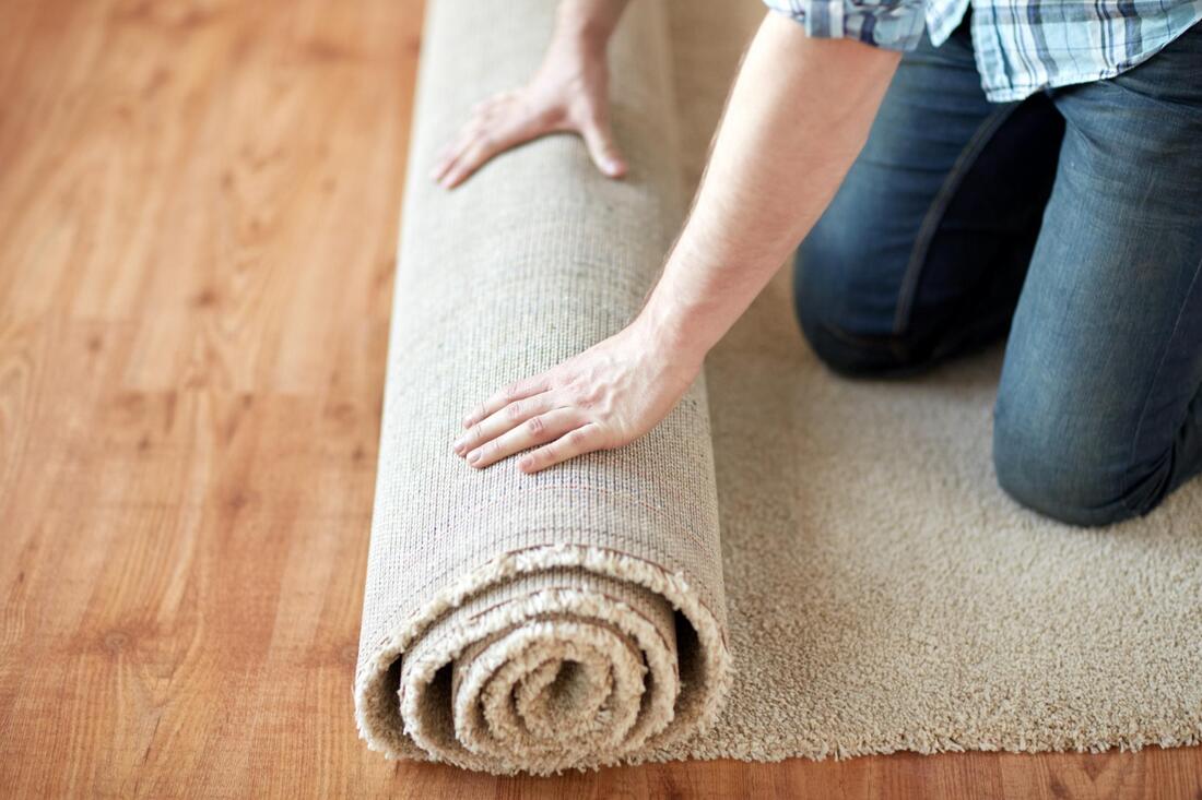 a man rolling up a carpet